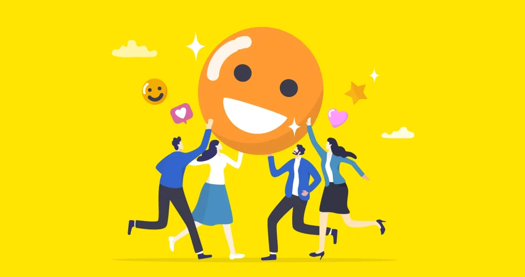 Ilustración de un emoticono gigante sonriente sostenido en brazos por distintos tipos de trabajadores, para hablar de la felicidad en el trabajo.